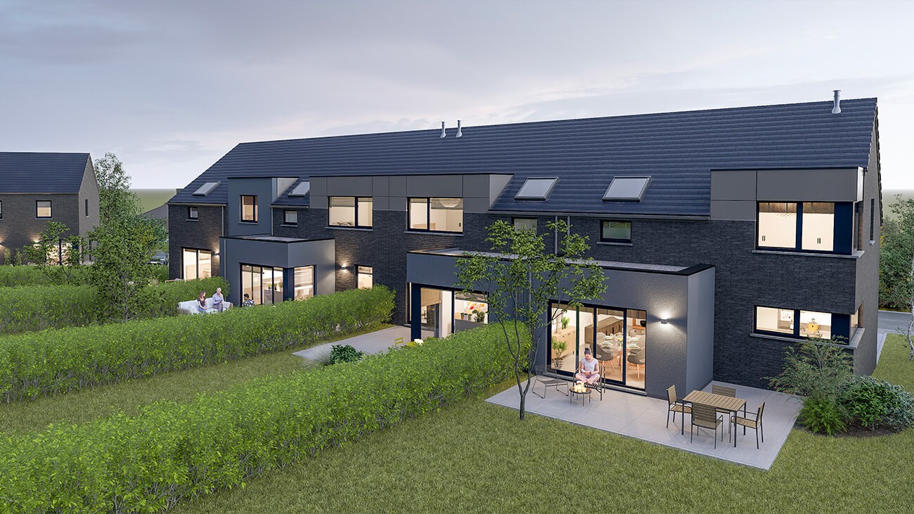 Une rangée moderne de maisons de ville à deux étages avec de grandes fenêtres et des patios privés, entourés de haies bien taillées et de pelouses vertes. Les gens se détendent à l'extérieur, profitant du début de soirée. Les Maisons à vendre Courcelles vous attendent.