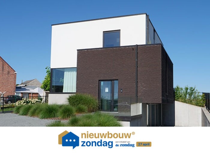 Moderne twee-onder-een-kapwoning met een witte en donkere bakstenen gevel, grote ramen en een plat dak. Omringd door groene planten en een grindpad. Onderaan het logo staat 'nieuwbouw zondag' met de datum 27 april.