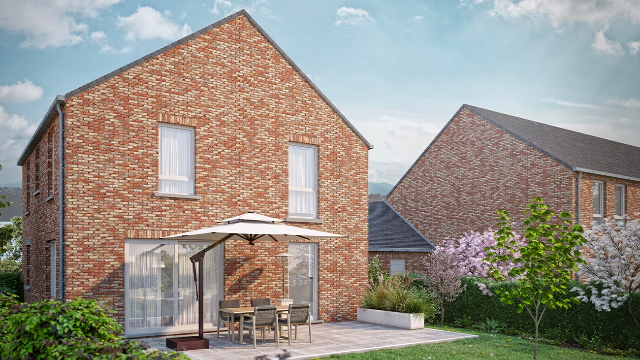 Une maison en briques rouges au toit en pente abrite un patio avec une table, des chaises et un grand parasol. Le jardin est aménagé avec des arbres et des arbustes à fleurs, et une autre maison similaire est visible en arrière-plan sous un ciel partiellement nuageux.