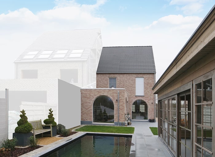Modern bakstenen huis met boogramen en een verzorgde tuin naast een smal zwembad. Een houten bank en vormsnoeiplanten staan links, met een tweede onafgebouwd huis op de achtergrond en een lucht met verspreide wolken.