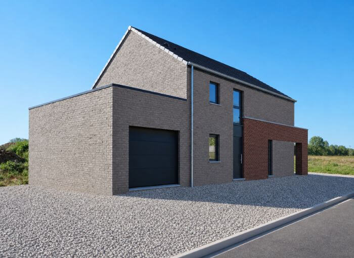 Maison moderne à deux étages, avec une façade en briques, une cour plate recouverte de gravier, une porte de garage noire, de grandes fenêtres et un ciel bleu limpide en arrière-plan.