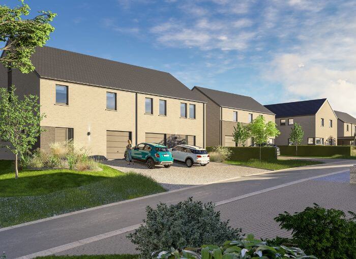 Une rangée de maisons modernes à deux étages, aux façades beiges, avec des pelouses soigneusement tondues et deux voitures garées dans l'allée par une journée ensoleillée. Des arbres et des arbustes bordent la rue dans ce quartier de banlieue.